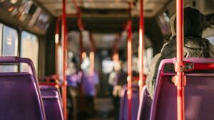 Interior of a quiet bus with purple seats and soft sunlight, symbolizing stillness and introspection.